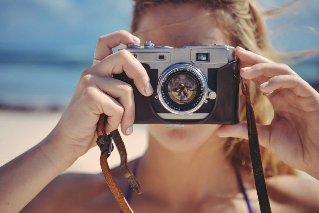 blonde woman holding a photo camera
